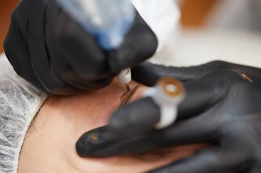 Kozmetik uzmanı kalıcı makyaj yapıyor