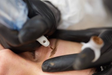 Kozmetik uzmanı kalıcı makyaj yapıyor