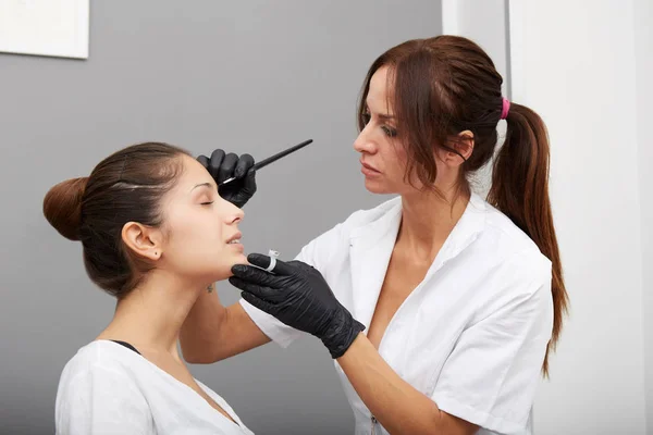 Cosmetoloog die permanente make-up op wenkbrauwen aanbrengt — Stockfoto
