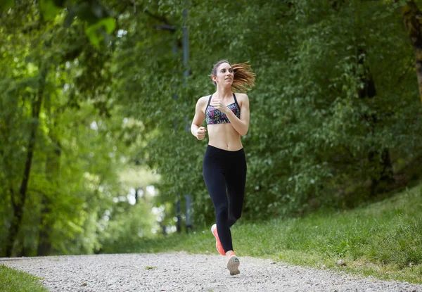 Unga attraktiva sport flicka kör i park — Stockfoto