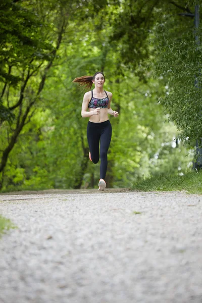 Jeune fille sportive attrayante courir dans le parc — Photo