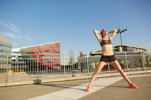 Oefenen met stedelijke achtergrond van wolkenkrabbers skyline vrouw uitvoeren — Stockfoto