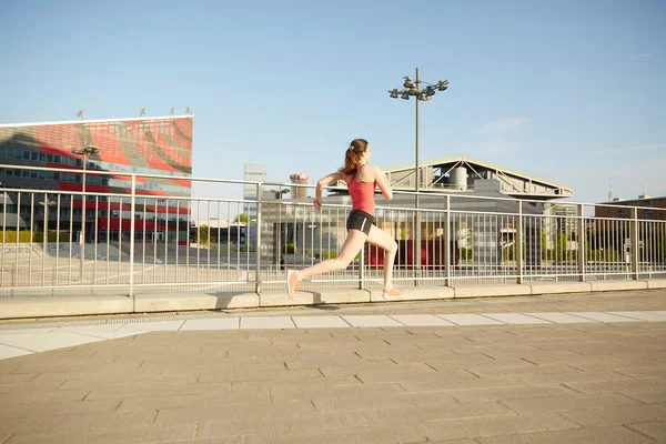 Запустити жінку вправи з міським фоном хмарочосів горизонту — стокове фото