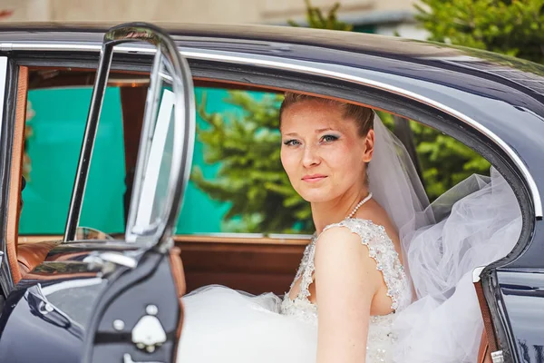 Retrato de la novia sentada en el coche — Foto de Stock