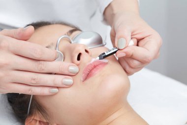 Beautician Giving Epilation Laser Treatment To Woman On lips clipart