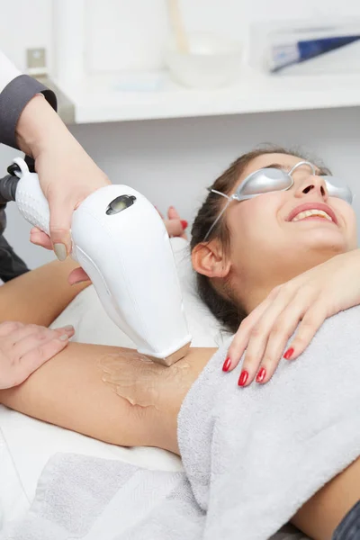 Beautician Giving Epilation Laser Treatment To Woman On underarm
