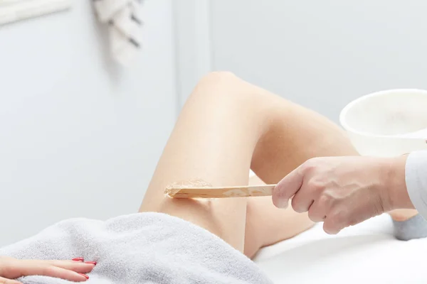 Beautician Giving Epilation wax Treatment To Woman On Thigh