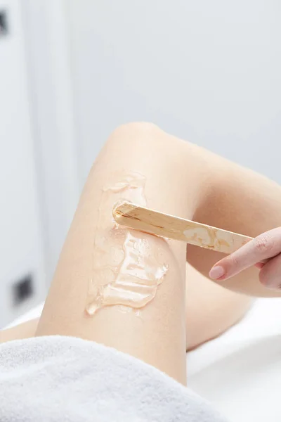 Beautician Giving Epilation wax Treatment To Woman On Thigh