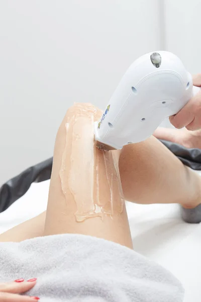 Schoonheidsspecialiste geven epilatie laser behandeling naar vrouw op dij — Stockfoto