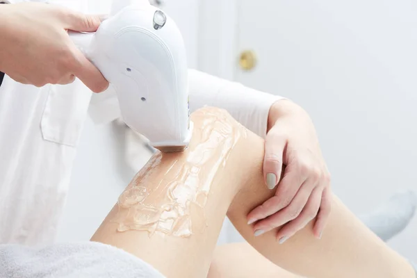 Estetista dando trattamento laser di epilazione alla donna sulla coscia — Foto Stock