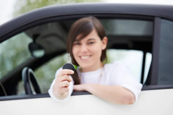 Menina alegre segurando chaves do carro da janela — Fotografia de Stock