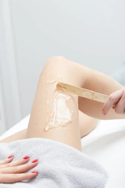 Młoda kobieta o nogi zabiegowi depilacji laserowej w salonie — Zdjęcie stockowe
