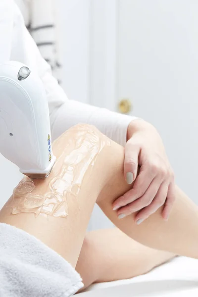 Giovane donna che ha gambe trattamento di depilazione laser nel salone — Foto Stock