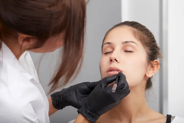 Tatoueur professionnel faisant maquillage permanent sur les lèvres — Photo