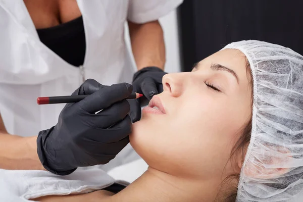 Professioneller Tätowierer, der Permanent Make-up herstellt. schöne Frau bekommt Tätowierung im Gesicht — Stockfoto