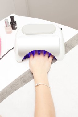 closeup jel tırnak cilası güzellik salonunda sabitleme içinde bir el ile bir uv lamba