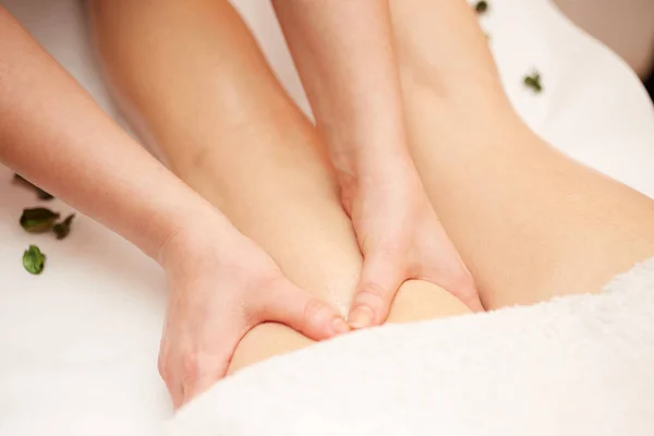 Détail des mains massant le mollet humain muscle.Therapist appliquant une pression sur la jambe féminine — Photo