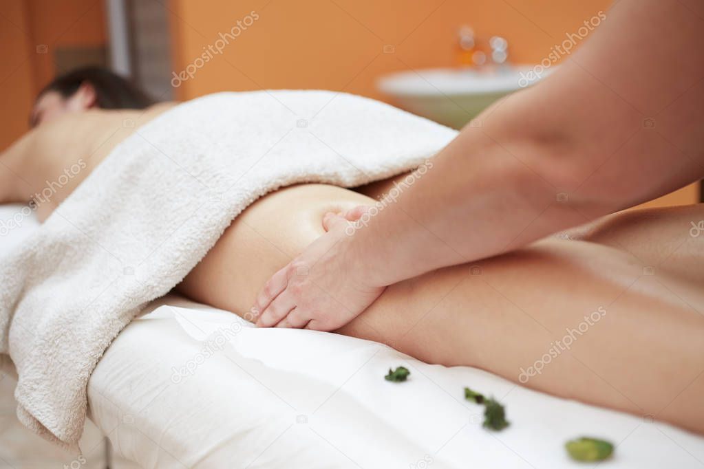 Detail of hands massaging human calf muscle.Therapist applying pressure on female leg