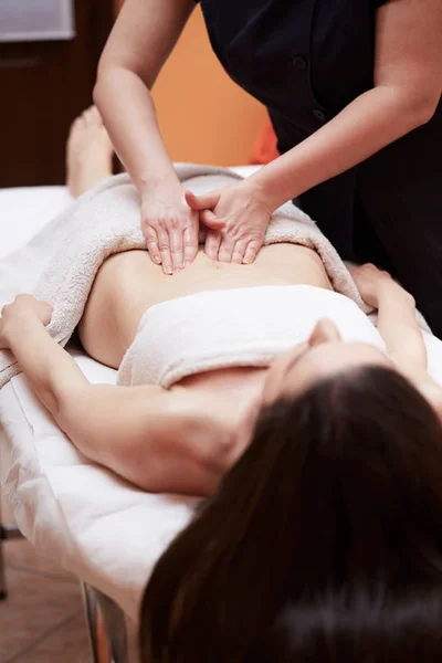 Een vrouw die een buik massage op spa salon — Stockfoto