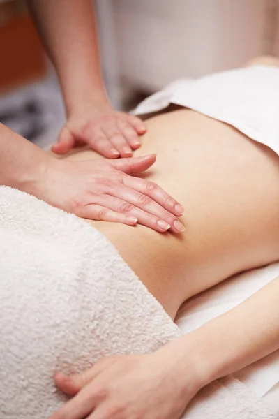 Uma mulher recebendo uma massagem na barriga no salão de spa — Fotografia de Stock