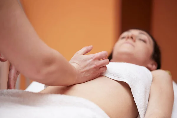 Uma mulher recebendo uma massagem na barriga no salão de spa — Fotografia de Stock