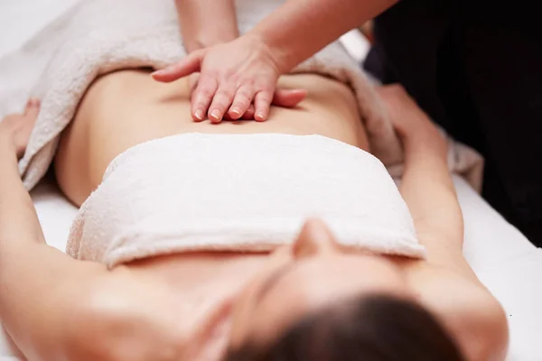 Uma mulher recebendo uma massagem na barriga no salão de spa — Fotografia de Stock