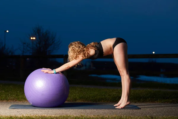 Женщина с мячом для йоги во время тренировки — стоковое фото