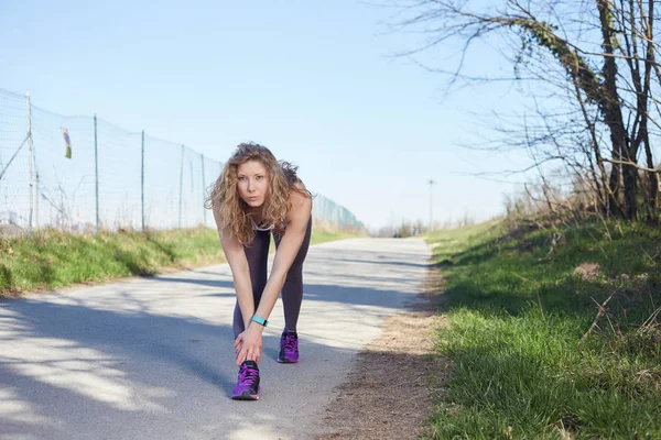 Mujer atlética haciendo ejercicio en el campo — Foto de Stock