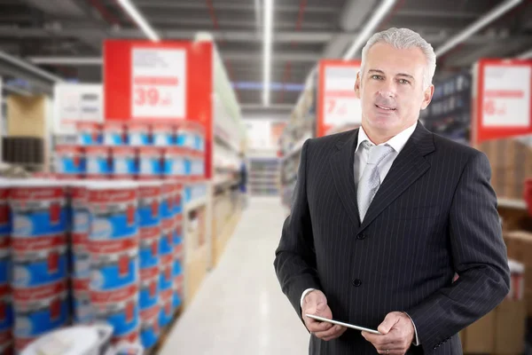 Улыбающийся взрослый бизнесмен-менеджер в супермаркете — стоковое фото