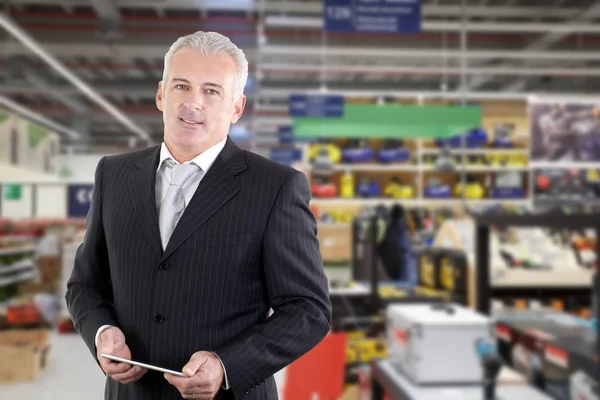 Улыбающийся взрослый бизнесмен-менеджер в супермаркете — стоковое фото