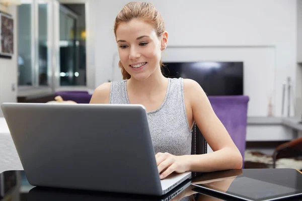 Cute woman using her notebook in her kitchen — Stock Photo, Image