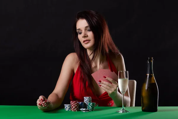 Mladá bruneta žena hrát poker na černém pozadí — Stock fotografie