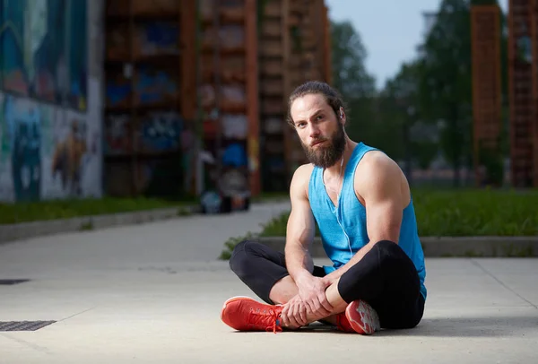 Après une bonne séance d'entraînement, un homme en forme et en bonne santé prend quelques instants pour se détendre — Photo