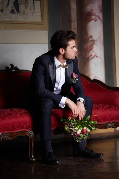 ソファの上に彼の花嫁を待っている若い新郎 — ストック写真