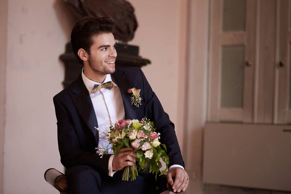groom looking and thinking  on a sofa