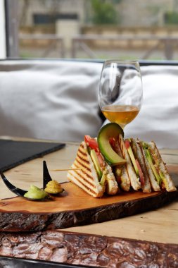 Vegan Club sandviç ahşap tepsi üzerinde avokado ile