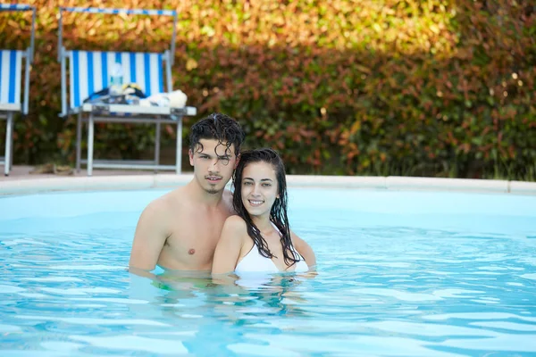 Jeune couple relaxant dans la piscine en été — Photo