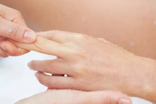 Frau bekommt im Heilbad eine Beauty-Behandlung mit Salz-Peeling an den Händen — Stockfoto