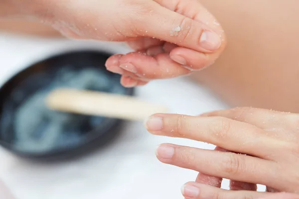 Vrouw krijgt een zout Scrub schoonheidsbehandeling op handen in de Health Spa — Stockfoto