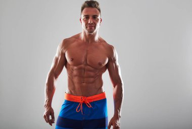 Yakışıklı kaslı genç adam stüdyo arka plan üzerinde uygun. 