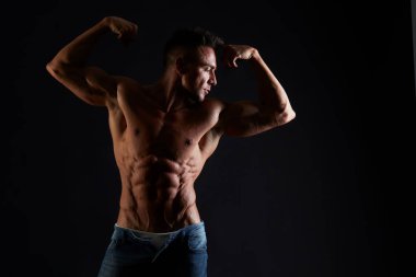 Yakışıklı kaslı genç adam stüdyo arka plan üzerinde uygun. 