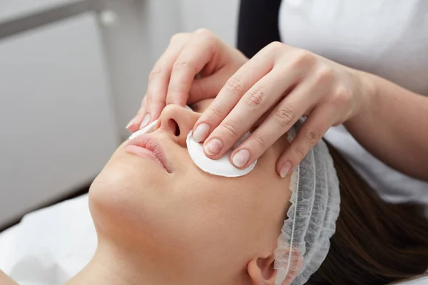 Ontspannende mooie vrouw met een massage voor haar huid op een gezicht in schoonheidssalon — Stockfoto