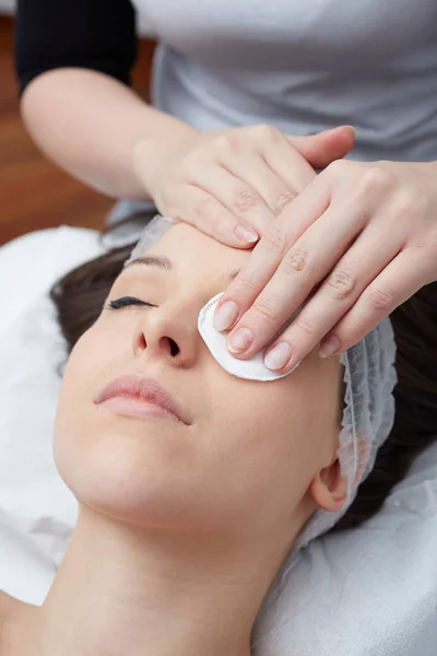 Entspannende schöne Frau mit einer Massage für ihre Haut auf einem Gesicht im Schönheitssalon — Stockfoto