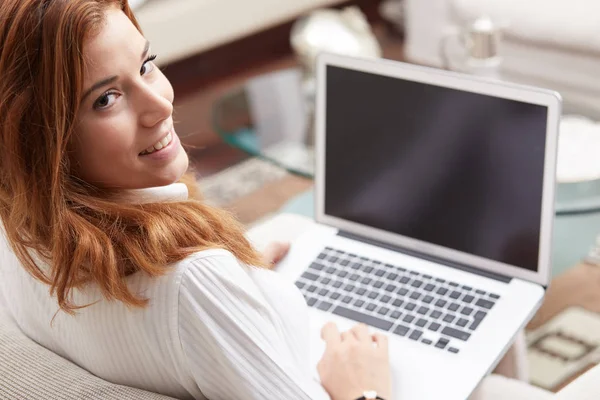 Красива жінка робить онлайн покупки з ноутбуком вдома у вітальні — стокове фото
