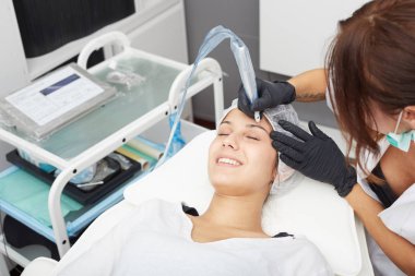 Kadının yüzünde kalıcı makyaj yapma güzellik uzmanı