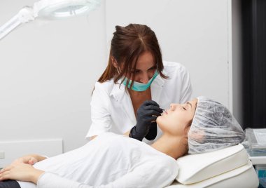 Kadının yüzünde kalıcı makyaj yapma güzellik uzmanı