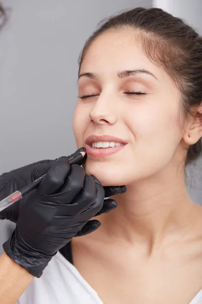 Schoonheidsspecialist maken van permanente make-up op vrouw gezicht — Stockfoto