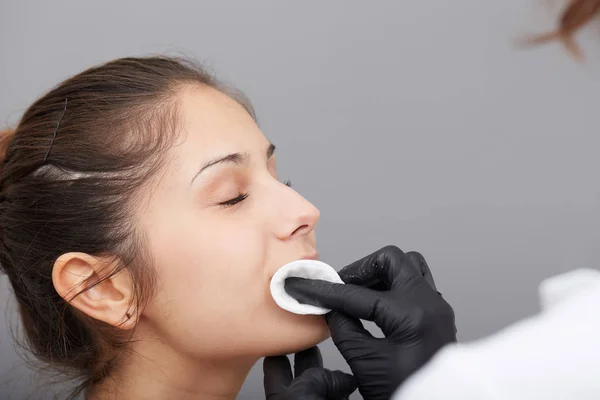 Kosmetikerin schminkt das Gesicht einer Frau dauerhaft — Stockfoto