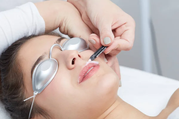 Kosmetolog göra permanent makeup på kvinnans ansikte — Stockfoto