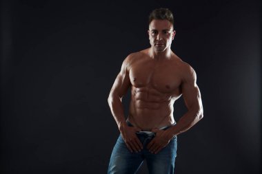 Genç seksi kaslı adam stüdyo arka planda poz